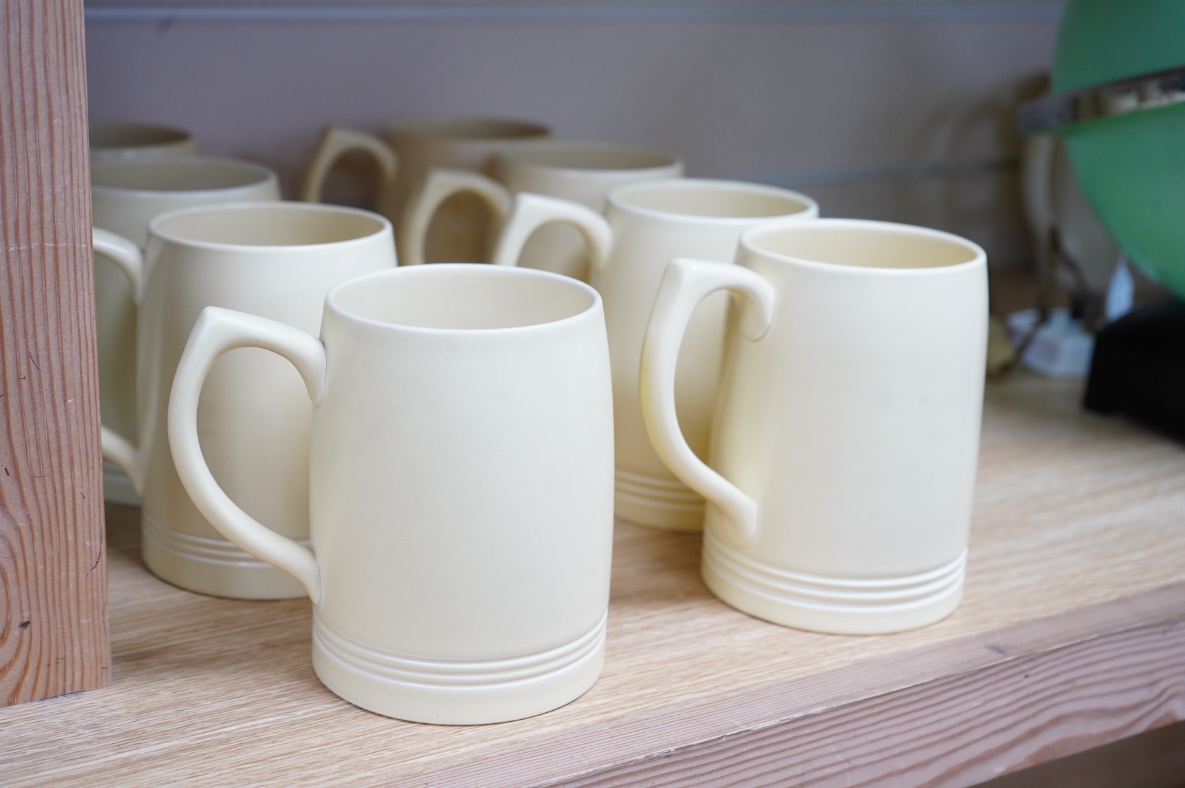 Keith Murray for Wedgwood, a set of eight straw glazed mugs, 12cm high